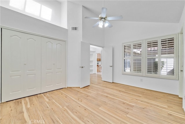 unfurnished bedroom featuring ceiling fan, light hardwood / wood-style flooring, and high vaulted ceiling