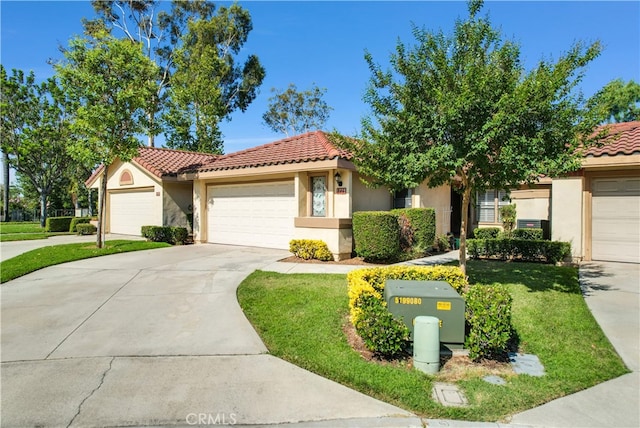 mediterranean / spanish-style house featuring a garage and a front lawn