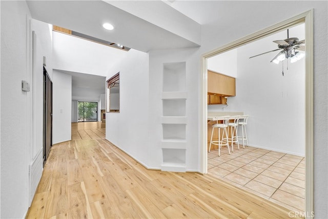 hallway featuring light wood-type flooring and built in features