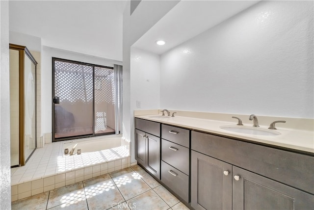 bathroom featuring vanity, a washtub, and tile patterned floors