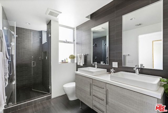 bathroom with toilet, a shower with door, and vanity