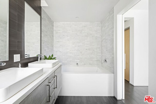 bathroom featuring tile walls, a washtub, and vanity