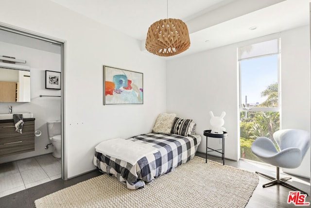 tiled bedroom with ensuite bathroom, sink, and multiple windows