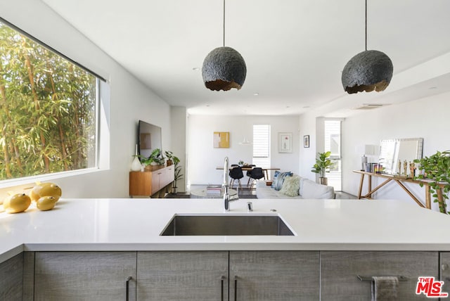 kitchen featuring decorative light fixtures, a wealth of natural light, and sink