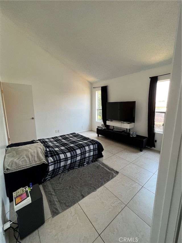 tiled bedroom with a textured ceiling and vaulted ceiling