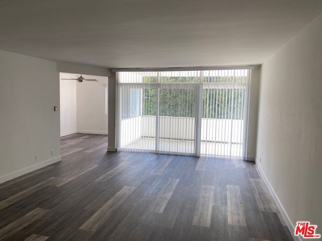 empty room with ceiling fan, floor to ceiling windows, and dark hardwood / wood-style flooring