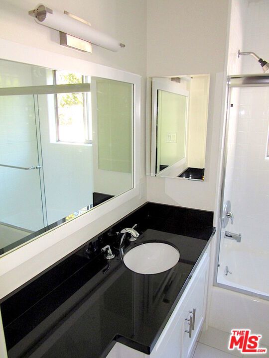 bathroom featuring shower / bathtub combination, vanity, and tile patterned flooring