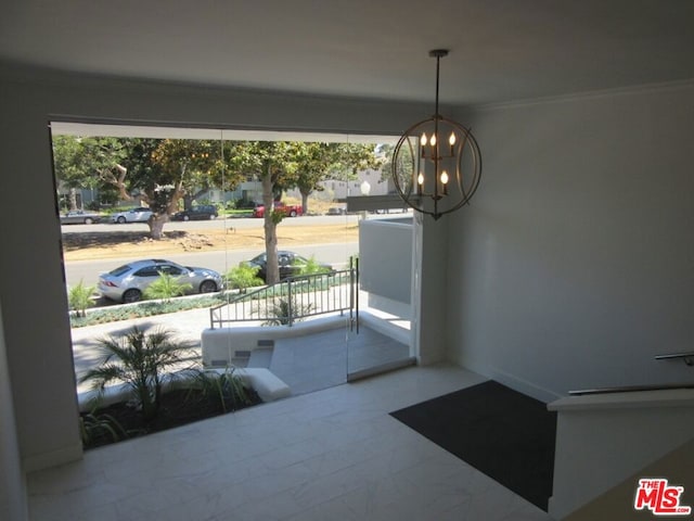 entryway featuring crown molding, a healthy amount of sunlight, and a chandelier