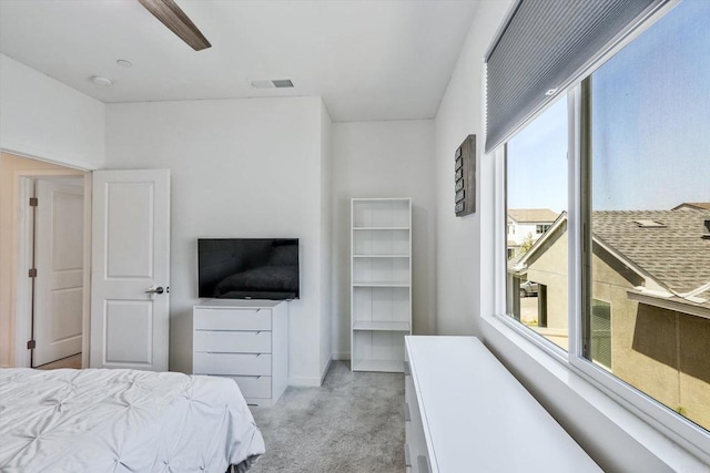 bedroom featuring light colored carpet, multiple windows, and ceiling fan