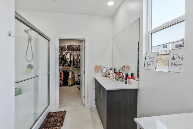 bathroom with tile patterned flooring, vanity, and a shower with shower door