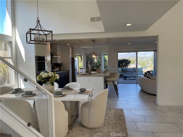 tiled dining space featuring sink and a chandelier