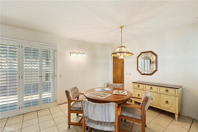 tiled dining room with a chandelier