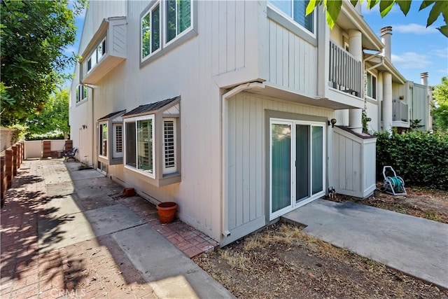 view of property exterior with a balcony and a patio area