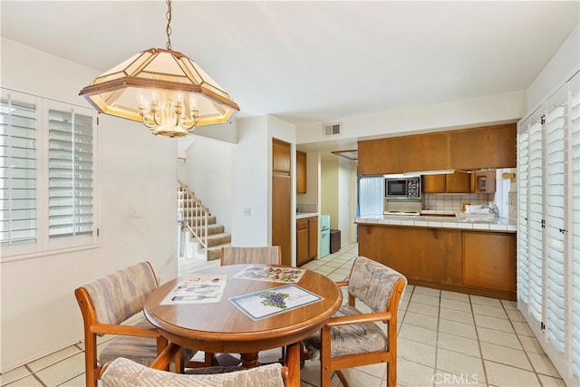 tiled dining space with a notable chandelier