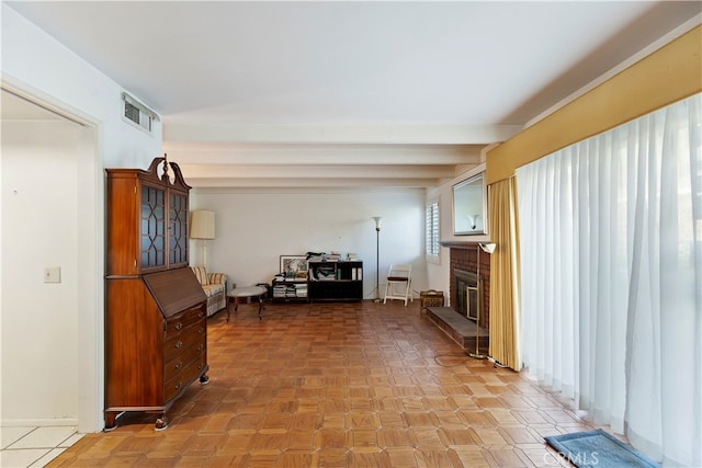 living room featuring beam ceiling and a fireplace