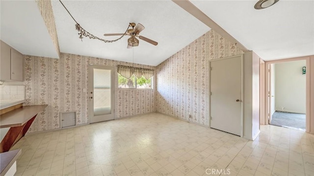 empty room featuring ceiling fan and vaulted ceiling