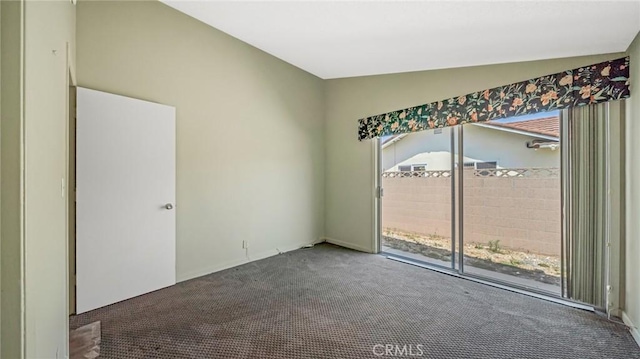 carpeted spare room with vaulted ceiling