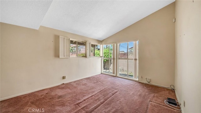 carpeted empty room with a textured ceiling and vaulted ceiling