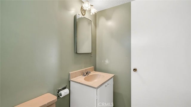 bathroom featuring vanity, a textured ceiling, and toilet