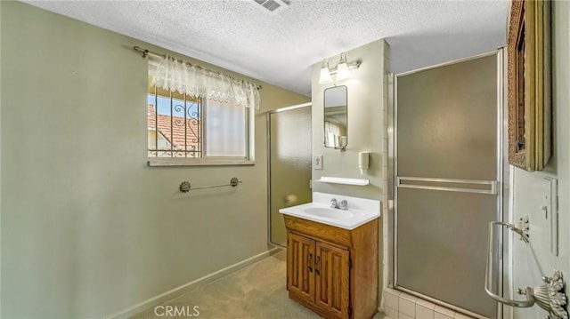 bathroom featuring vanity, a shower with door, and a textured ceiling