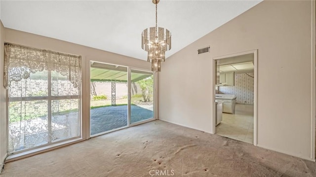 carpeted empty room with lofted ceiling and a chandelier