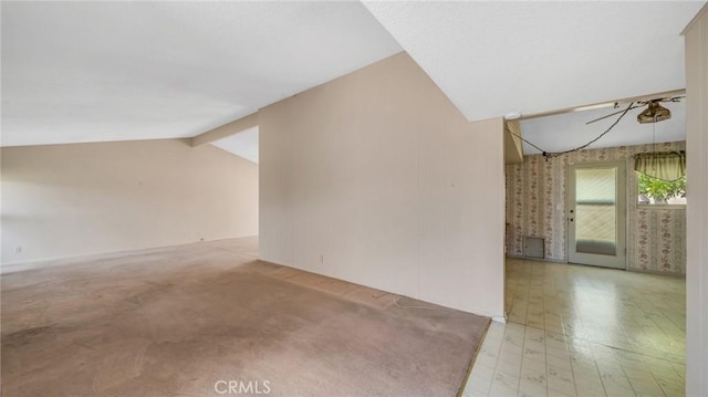 interior space with light carpet and lofted ceiling with beams