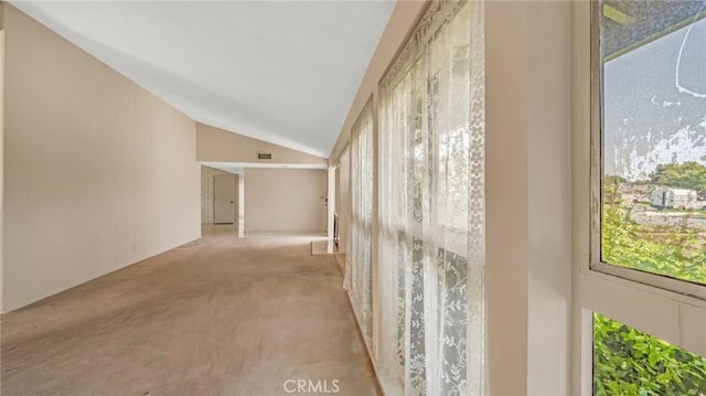 corridor with light colored carpet and lofted ceiling