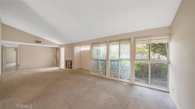 carpeted empty room featuring vaulted ceiling