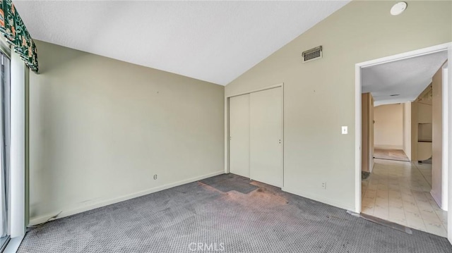 unfurnished bedroom with a closet, carpet, and vaulted ceiling