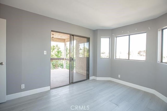 empty room with a wealth of natural light and light wood-type flooring