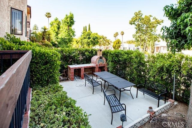 view of patio featuring an outdoor brick fireplace