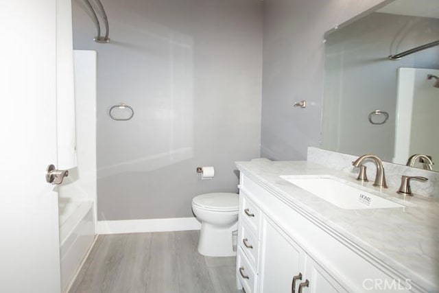 full bathroom featuring hardwood / wood-style flooring, vanity, washtub / shower combination, and toilet