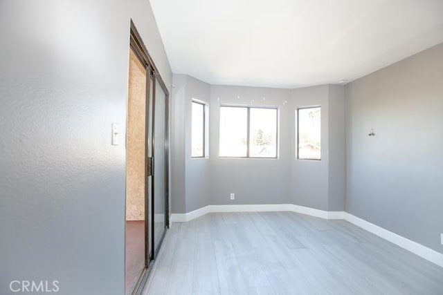 spare room featuring a barn door and light wood-type flooring