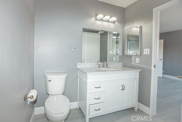 bathroom with vanity, hardwood / wood-style floors, and toilet