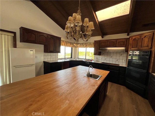 kitchen with decorative backsplash, sink, black appliances, pendant lighting, and lofted ceiling with beams