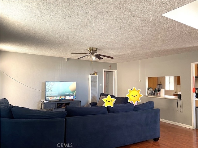 living room with ceiling fan, a textured ceiling, and dark hardwood / wood-style flooring