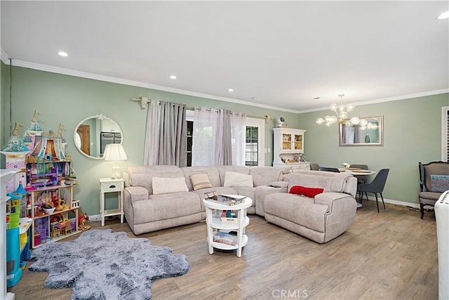 living room with crown molding, light hardwood / wood-style floors, and a chandelier