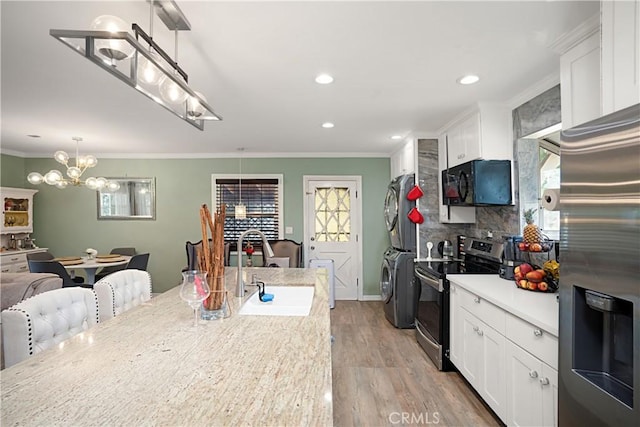 kitchen with stainless steel appliances, decorative light fixtures, sink, and white cabinets