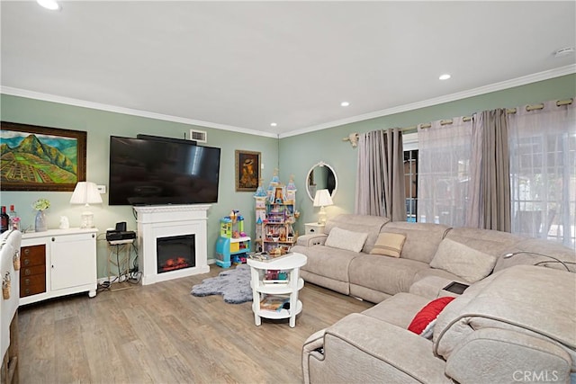 living room featuring crown molding and light hardwood / wood-style floors