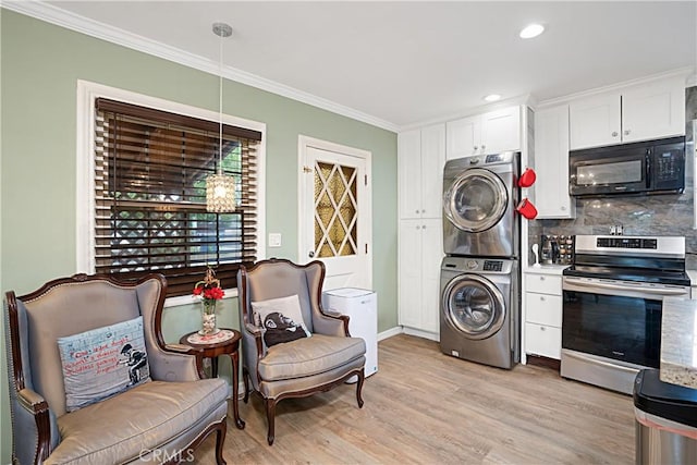 kitchen featuring decorative light fixtures, white cabinetry, stacked washer and dryer, electric range, and light hardwood / wood-style flooring