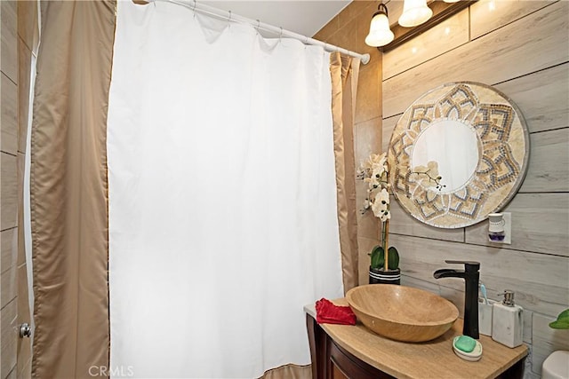 bathroom featuring vanity and wood walls