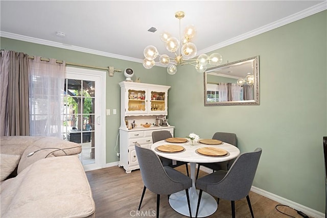 dining space with dark hardwood / wood-style flooring, crown molding, and a chandelier