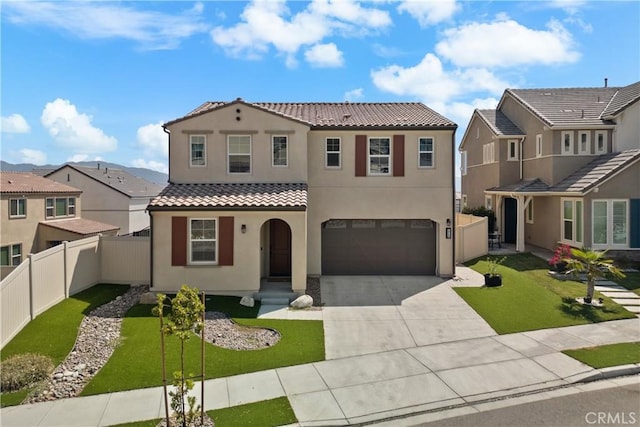 mediterranean / spanish-style home featuring a front yard and a garage