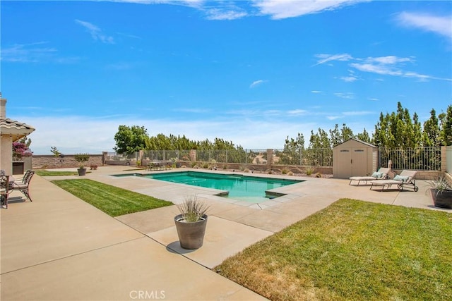 view of swimming pool featuring a yard, a patio area, and a storage shed