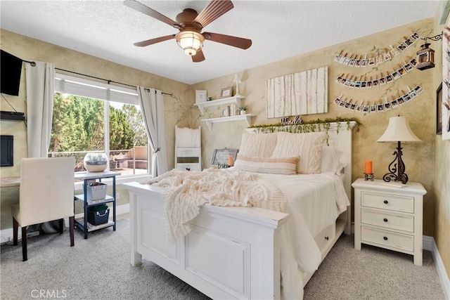 carpeted bedroom with ceiling fan and a textured ceiling