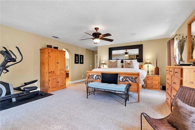 bedroom featuring light carpet, a textured ceiling, and ceiling fan