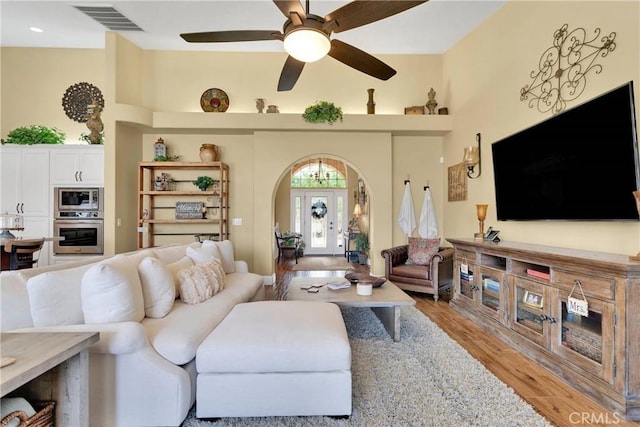 living room with hardwood / wood-style flooring, ceiling fan, and french doors