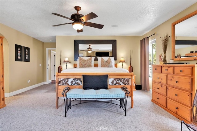 carpeted bedroom featuring ceiling fan and a textured ceiling