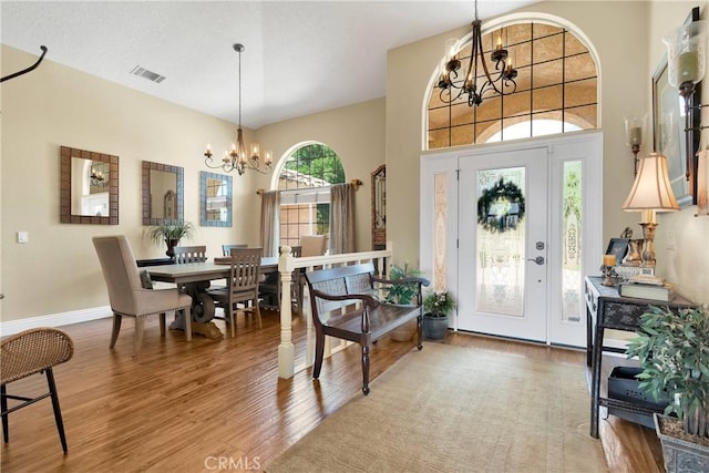 foyer with hardwood / wood-style floors and a chandelier