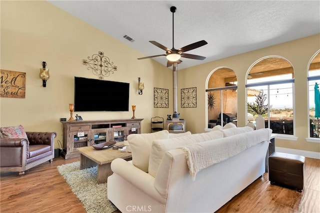 living room featuring a textured ceiling, light wood-type flooring, and ceiling fan